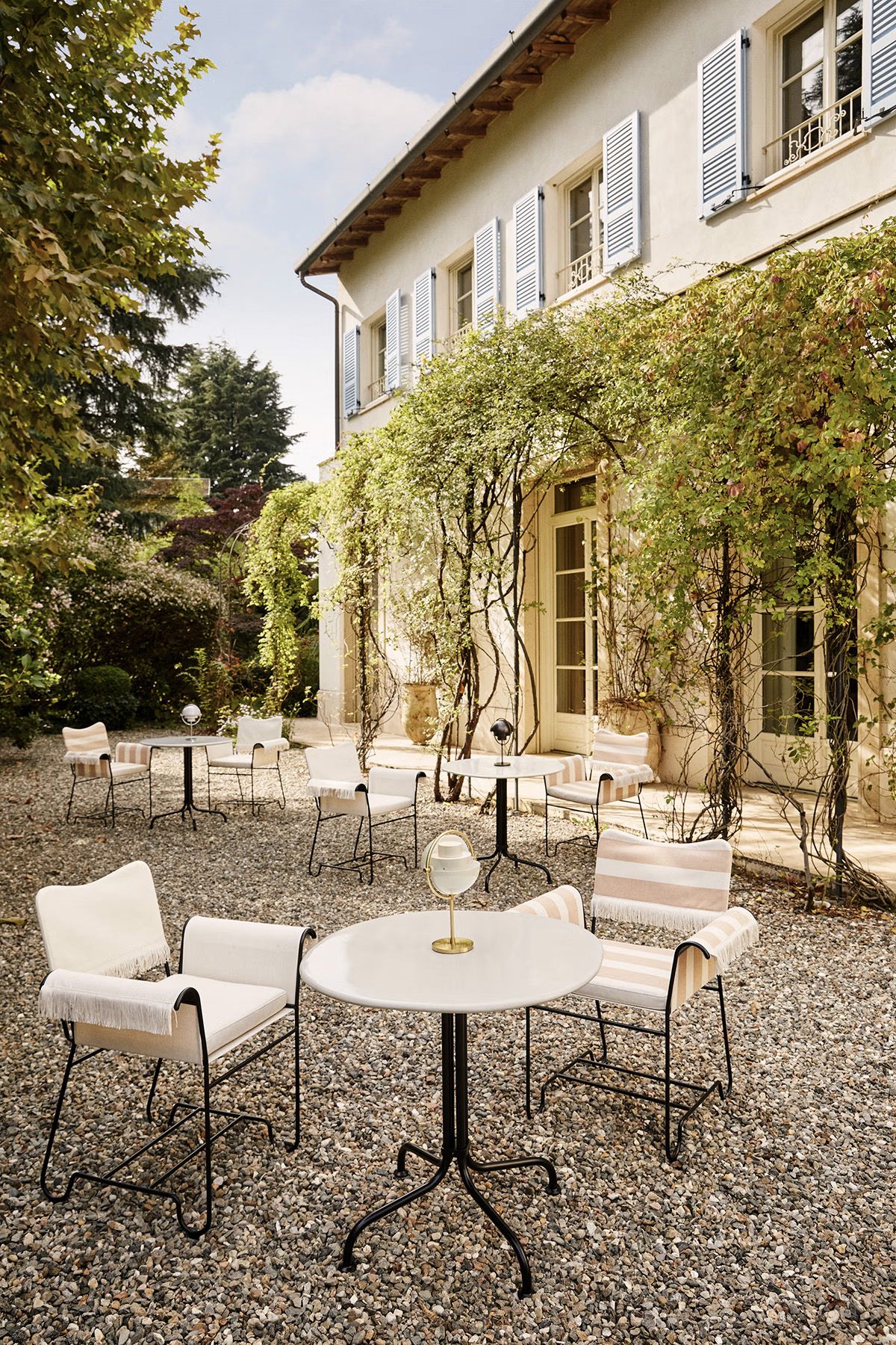 Elegant Clam White Carmel Bistro Table by OEO Studio for Gubi, featuring a weather-resistant ceramic top with rounded pebble-like silhouette and tree-like leg assembly.