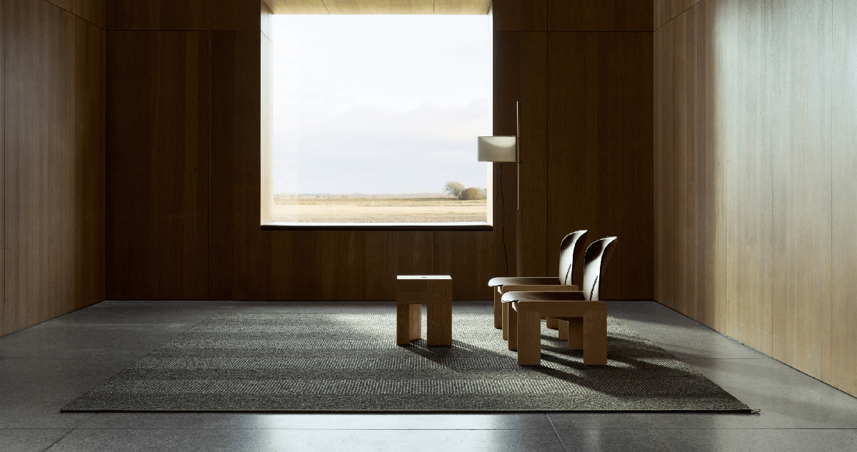 Sustainable luxury interior featuring Kasthall's groundbreaking Fasad collection rugs, designed by Sir David Chipperfield's team, demonstrating the elegant versatility of recycled wool in high-end design.