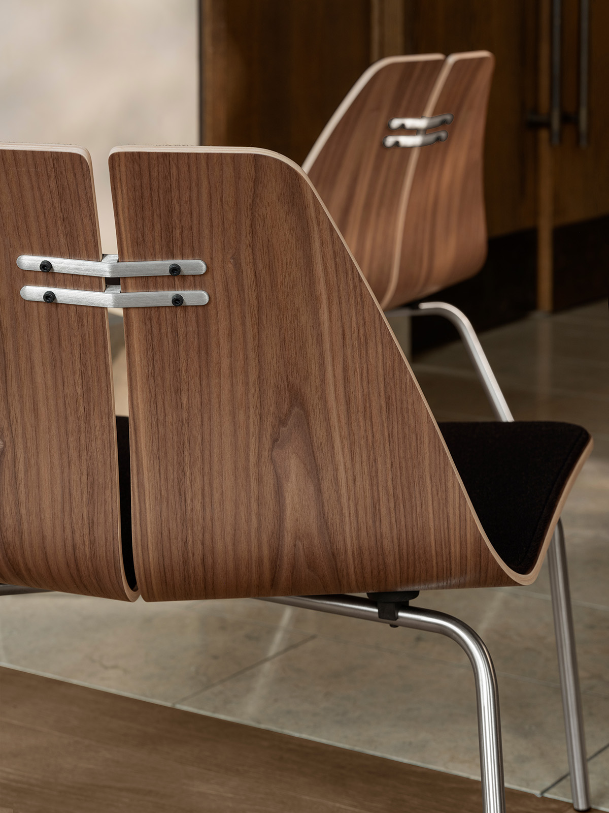 Poul Kjaerholm PK23 lounge chair in natural finish showcasing democratic design approach and accessibility