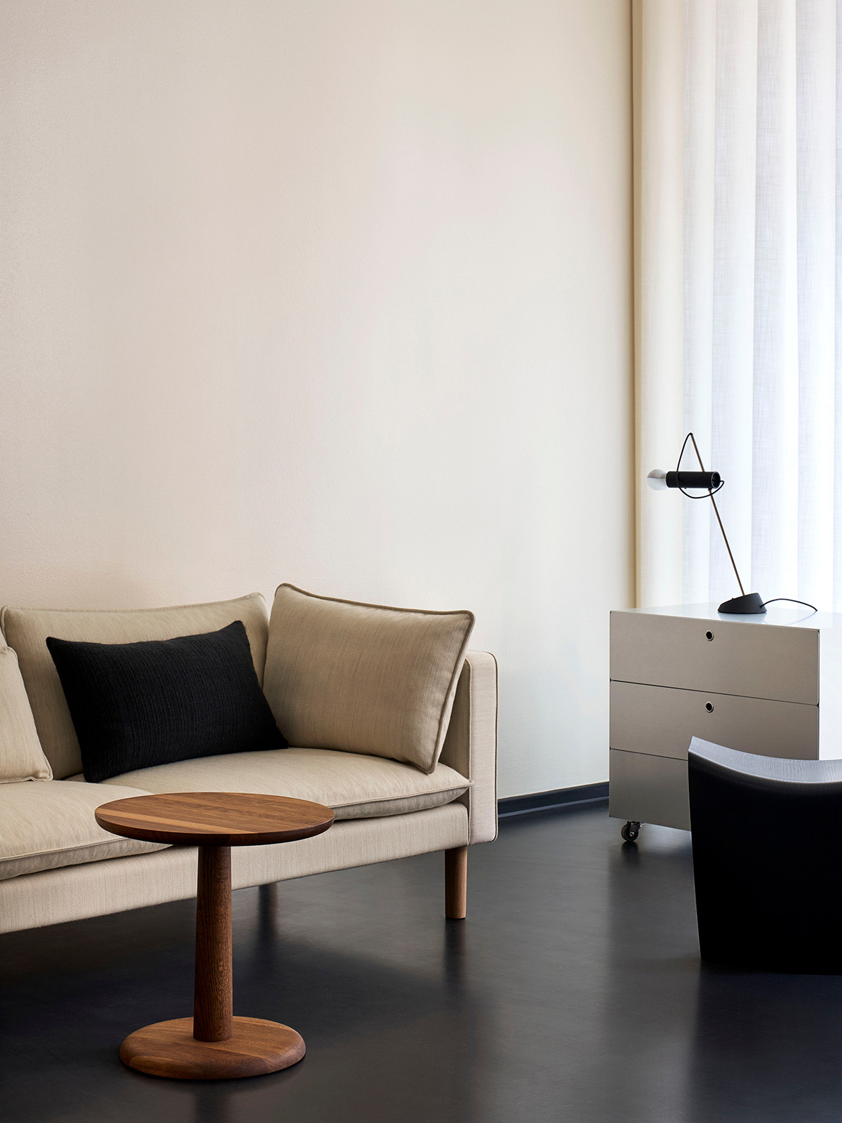 Upholstered components balance comfort with visual clarity. Refined seating depth and armrest height support extended use without excess padding. Refined upholstery detail of Jota Lounge sofa showing fabric weave, seating comfort proportions, and armrest form