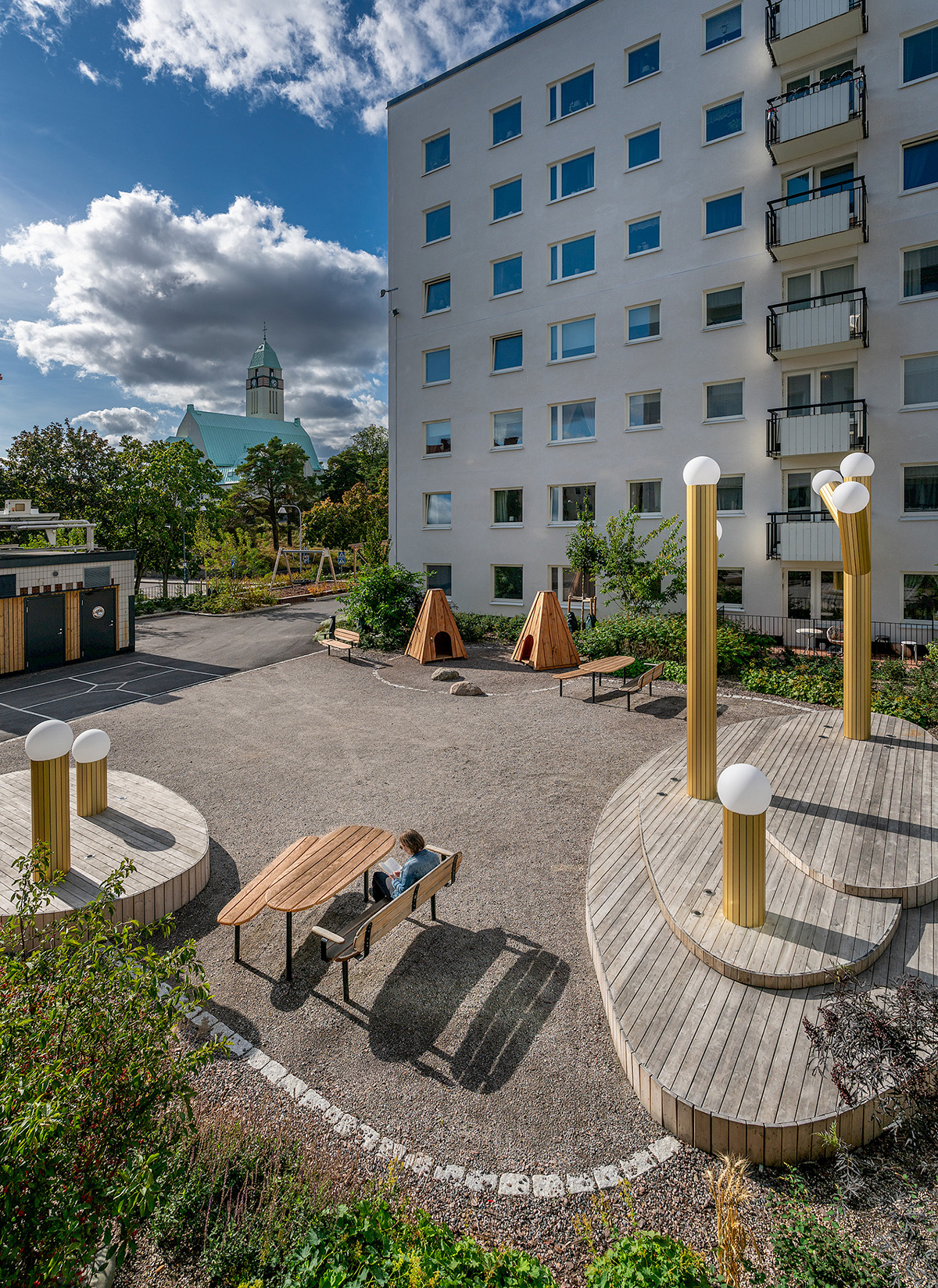 Island outdoor table and benches by Färg & Blanche for Nola in a residential courtyard